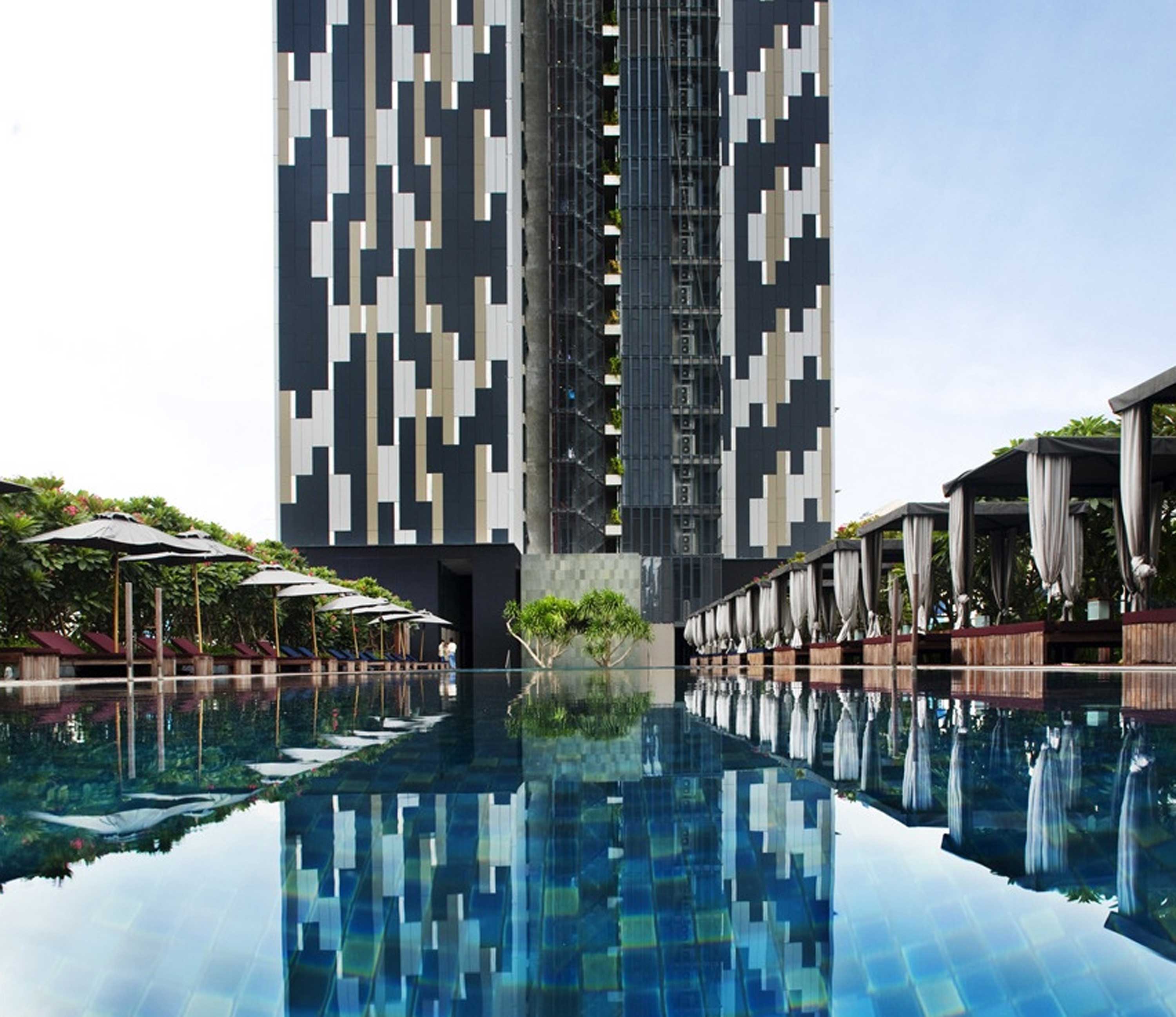 The Met Sathorn swimming pool with cabanas and the tower behind